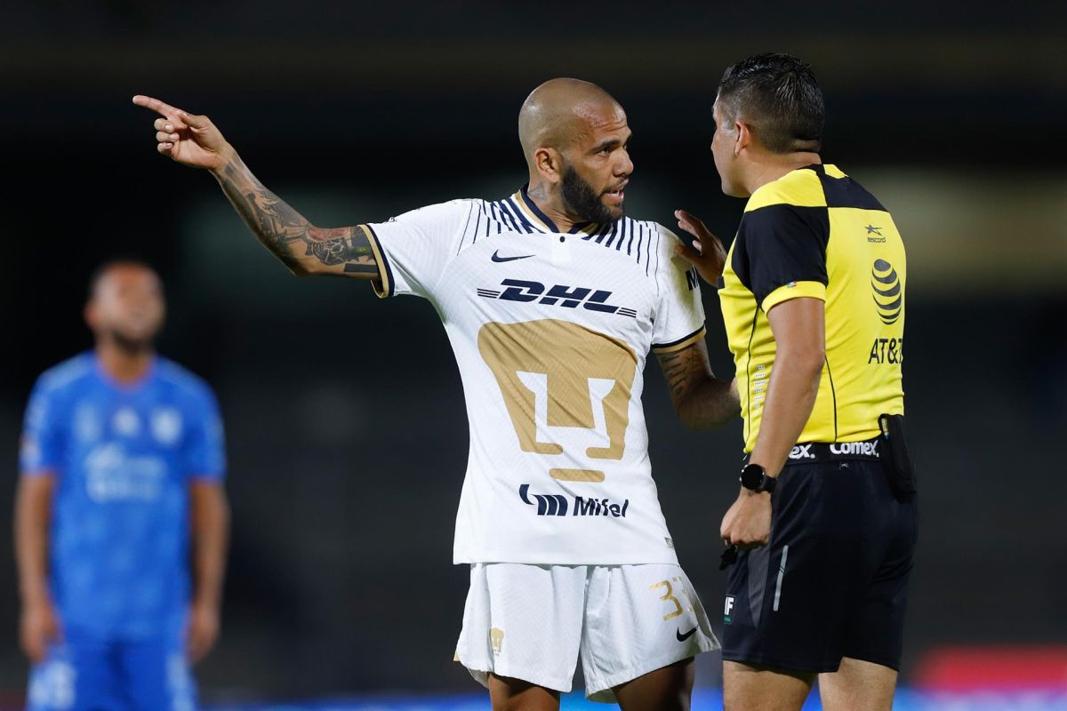 Dani Alves (i) de Pumas reclama al árbitro central Óscar Mejía hoy, durante un juego ante Tigres de la jornada 16 del torneo mexicano de fútbol.