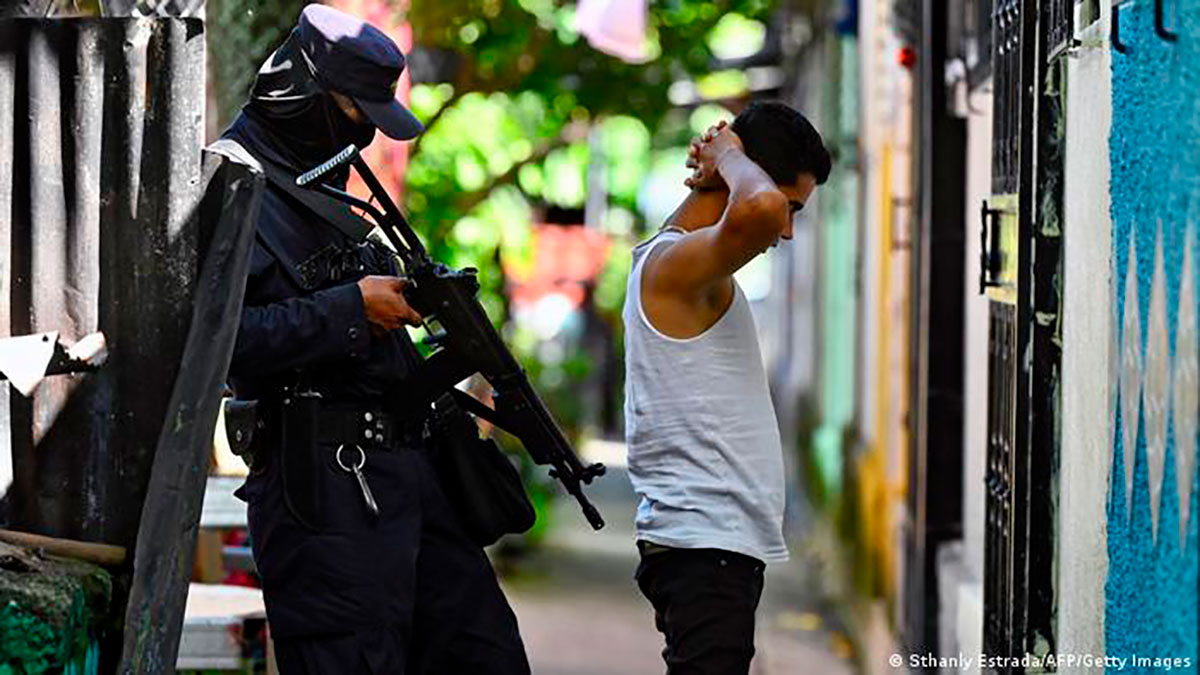 Un agente de policía interroga a un joven durante un operativo de seguridad contra las pandillas en Soyapango, al este de San Salvador. (16.08.2022)