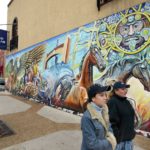 Dos mujeres pasan ante un mural en el vecindario hispano "La Villita" en Chicago.