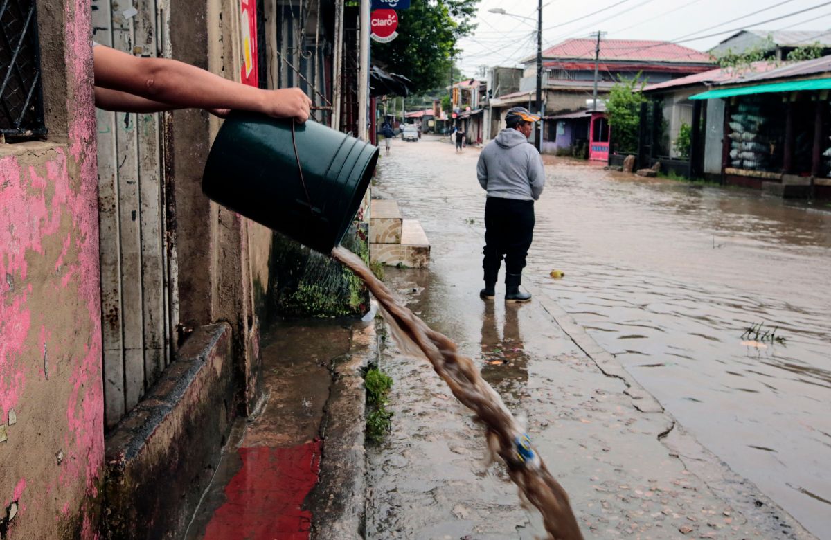 Un residente saca agua con baldes de su casa tras el paso del huracán Julia en la ciudad de Bluefields, en la costa caribeña de Nicaragua.