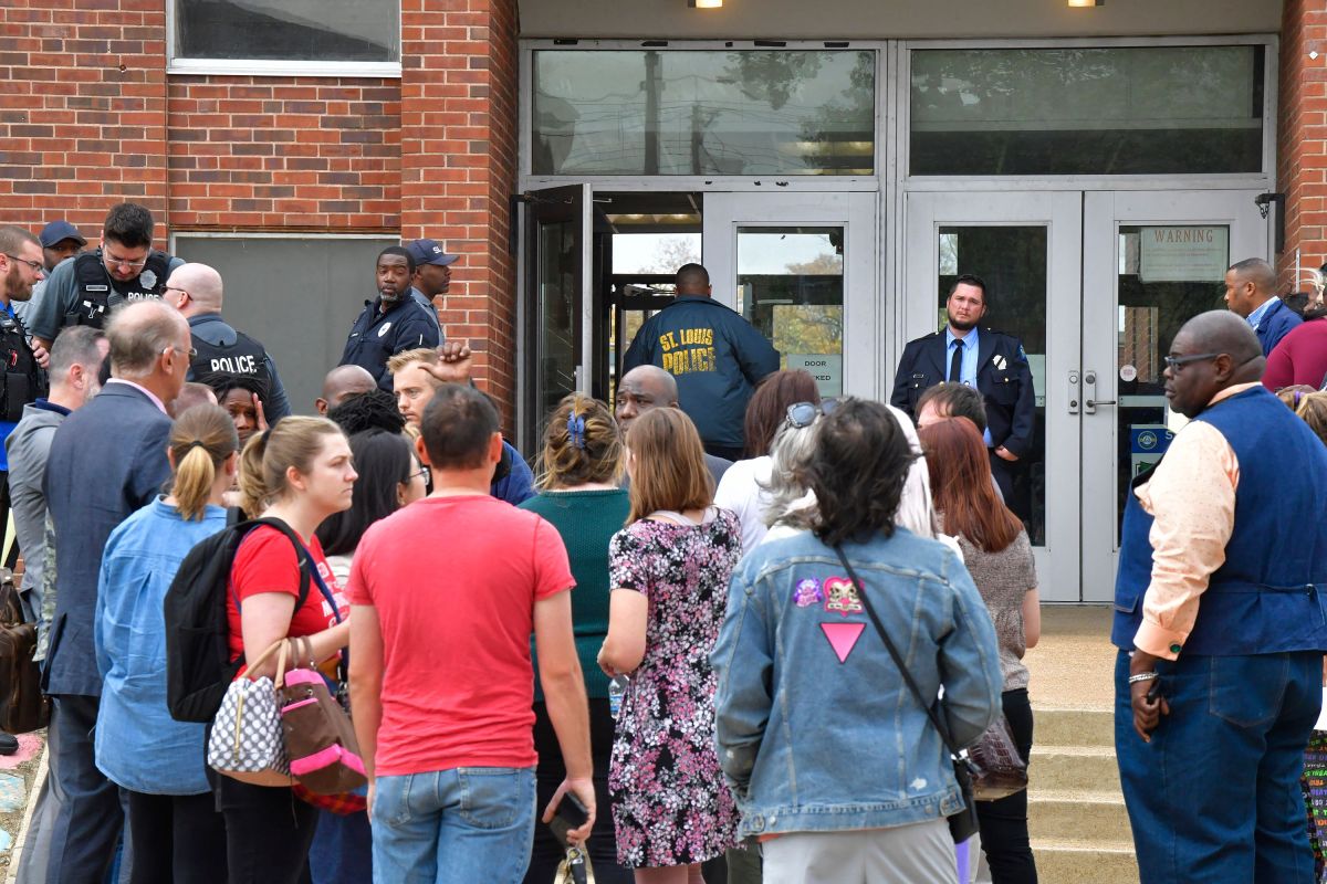 Policías de St. Louis y funcionarios escolares frente a la entrada sur de la Escuela Secundaria Central de Artes Visuales y Escénicas. 