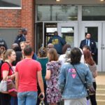 Policías de St. Louis y funcionarios escolares frente a la entrada sur de la Escuela Secundaria Central de Artes Visuales y Escénicas.