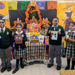 La maestra Florencia Terán y estudiantes de la escuela Our Lady of Guadalupe del este de Los Ángeles muestran su altar y decoraciones del Día de los Muertos. (Jacqueline García/La Opinión)