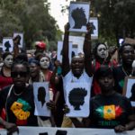 Participantes sostienen carteles con siluetas en una manifestación "contra las muertes en las fronteras" en Barcelona.