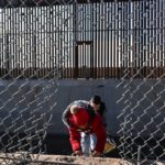 Una familia de migrantes cruza un agujero en el muro fronterizo en El Paso, Texas, el 19 de diciembre de 2022.
