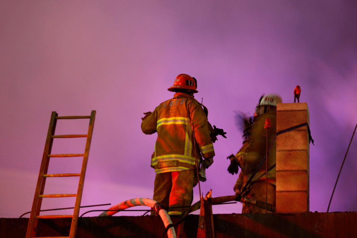 Docenas de bomberos formaban una línea para combatir el incendio frontalmente a medida que aumentaba su intensidad.