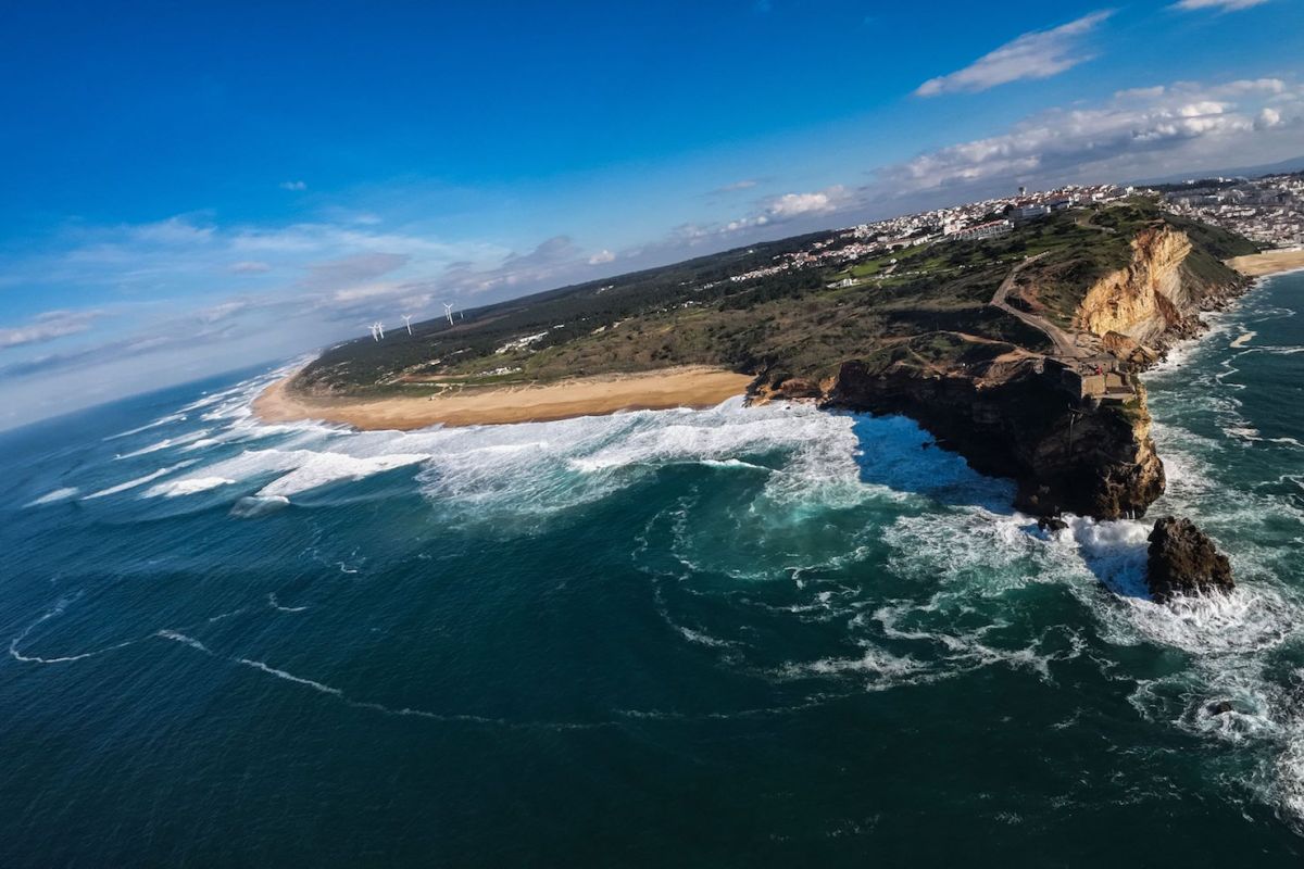 Una foto aérea tomada el 6 de enero de 2023 muestra el faro de la Praia do Norte en Nazare. - El surfista brasileño Marcio Freire murió el 5 de enero de 2023 mientras surfeaba las célebres olas del Atlántico en Portugal, donde se encuentra el "Cañón de Nazare", considerado uno de los mayores y más aterradores desafíos de este deporte