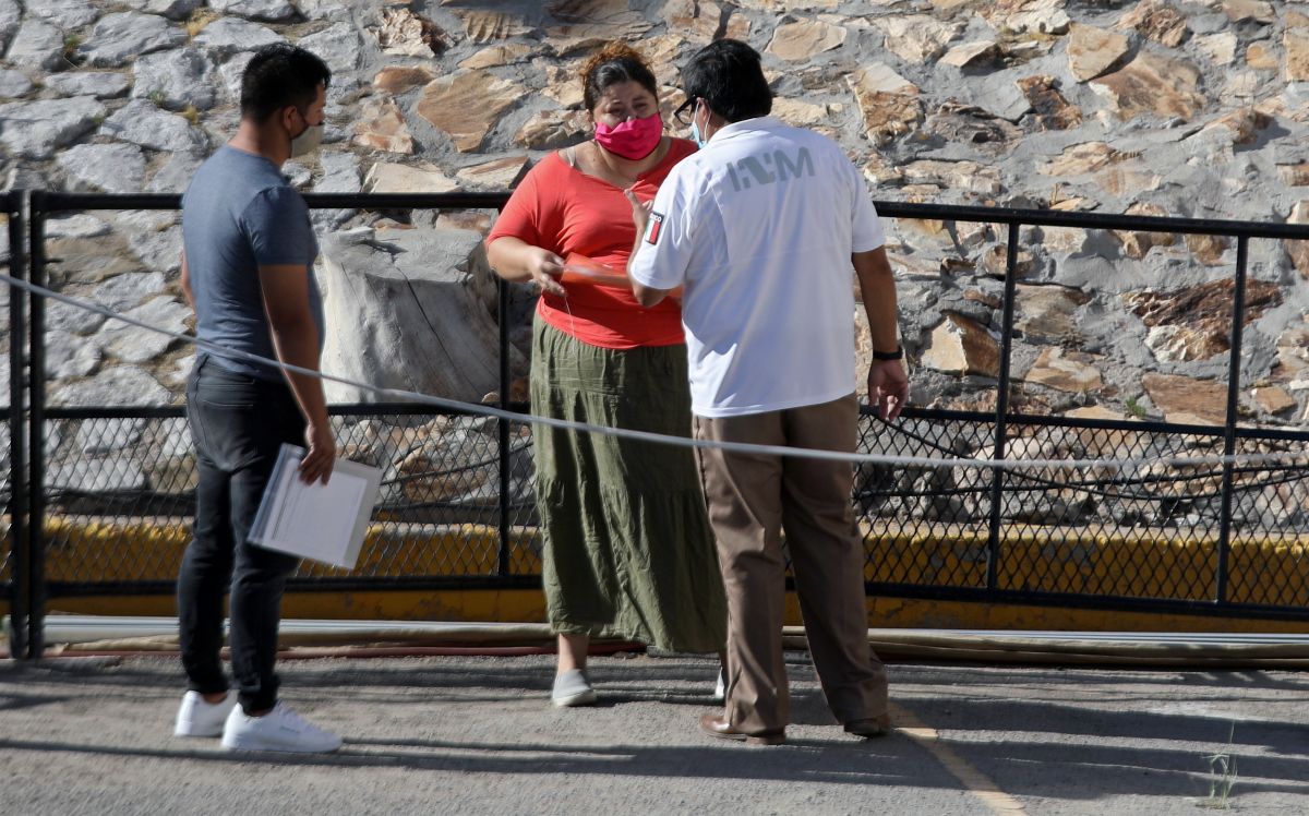 Un agente del INM de México da instrucciones a inmigrantes cubanos en Ciudad Juárez.