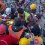 Rescatistas trasladan a una ambulancia a una mujer que sacaron de los escombros en Turquía.