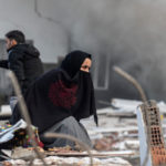 Mujer en Turquía busca a sus familiares atrapados debajo de un edificio derrumbado.