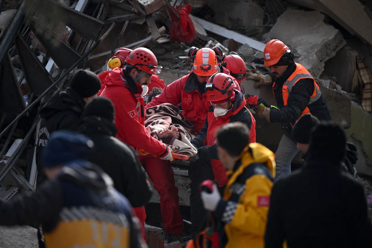 El personal de rescate lleva a un joven en una camilla a través de los escombros de los edificios en Kahramanmaras, el epicentro del terremoto.