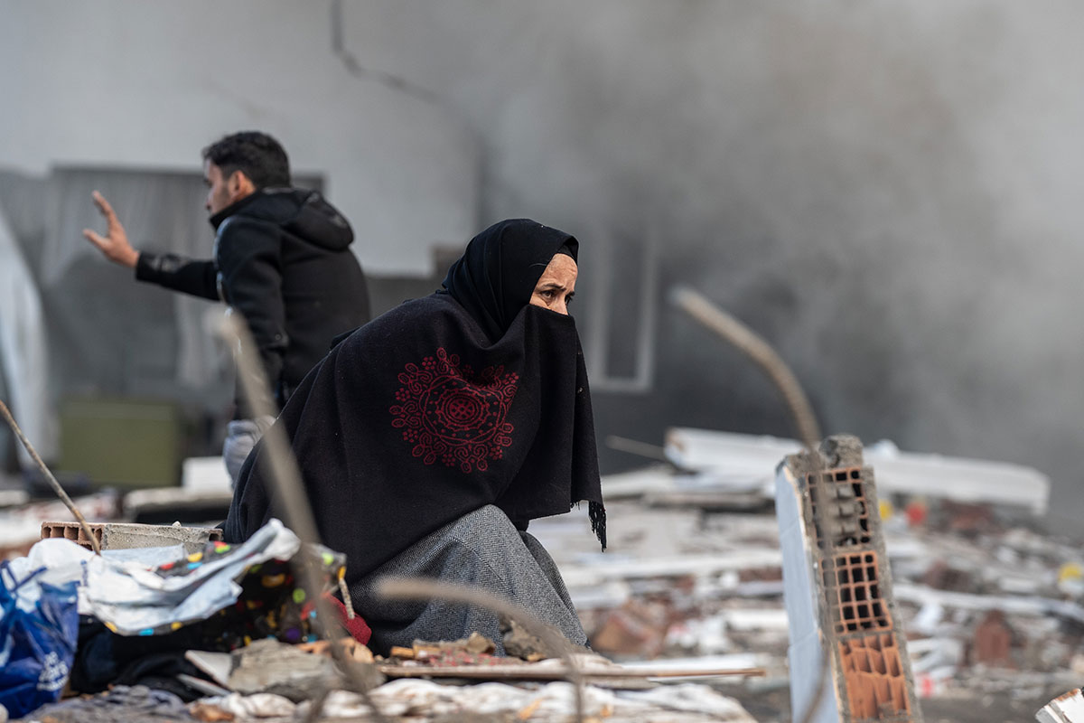 Mujer en Turquía busca a sus familiares atrapados debajo de un edificio derrumbado.