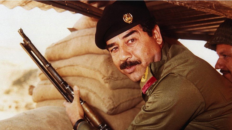 Saddam Hussein con un rifle durante su Presidencia.