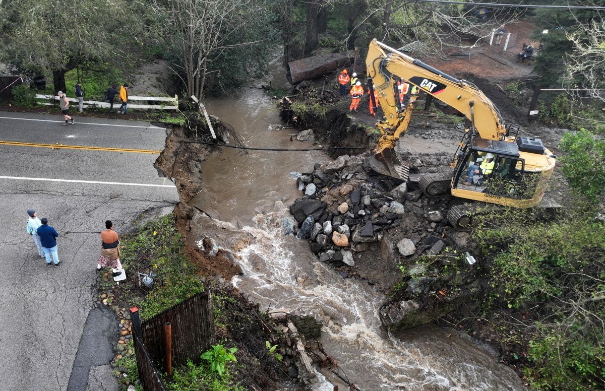 Trabajadores hacen reparaciones de emergencia en una carretera derrumbada en Soquel, California.