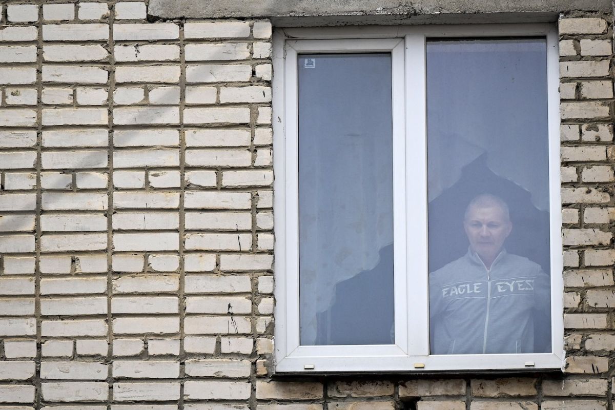 Alexei Moskalyov, padre soltero de Maria Moskalyova, la niña de 13 años que hizo un dibujo crítico con la campaña militar de Moscú en Ucrania en la escuela, mira por la ventana de su piso después de que le pusieran bajo arresto domiciliario por repetir posts sobre Ucrania desacreditando al ejército ruso.