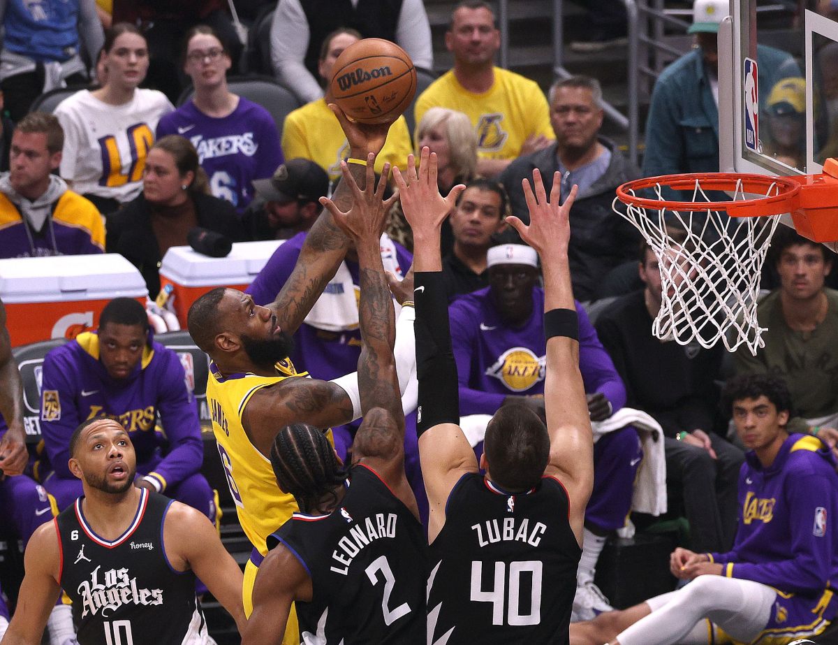 LOS ANGELES, CALIFORNIA - APRIL 05: LeBron James #6 of the Los Angeles Lakers scores on a layup in front of Eric Gordon #10 Kawhi Leonard #2 and Ivica Zubac #40 of the LA Clippers during the first half at Crypto.com Arena on April 05, 2023 in Los Angeles, California. NOTE TO USER: User expressly acknowledges and agrees that, by downloading and or using this photograph, User is consenting to the terms and conditions of the Getty Images License Agreement. (Photo by Harry How/Getty Images)