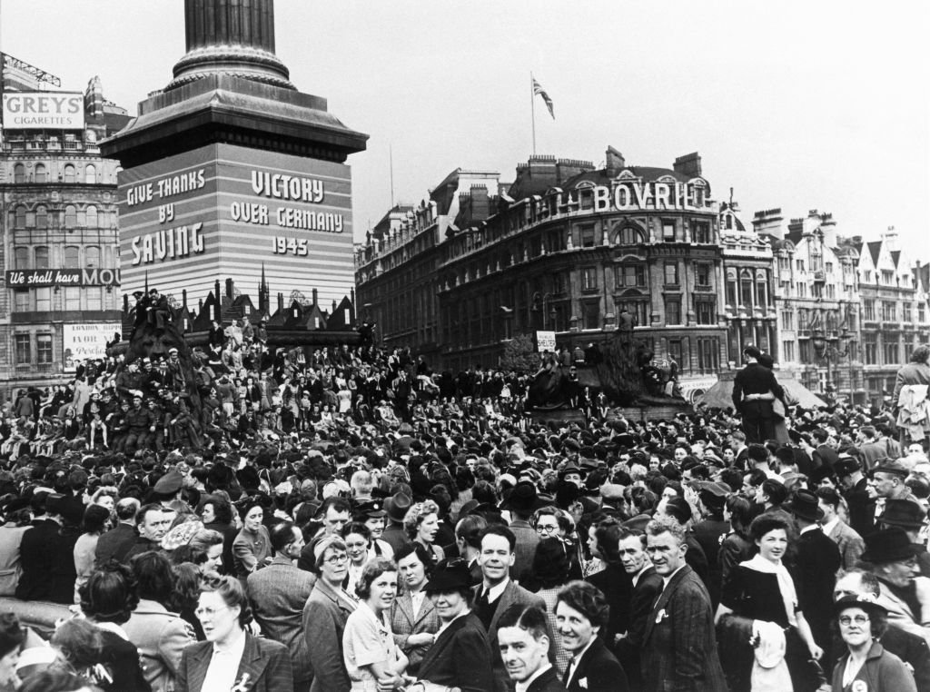 Personas en la Plaza de Trafalgar celebrando la victoria en Europa, mayo 1945