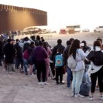 Inmigrantes que buscan asilo esperan para ser procesados por agentes de CBP después de cruzar a Arizona desde México el 11 de mayo de 2023.